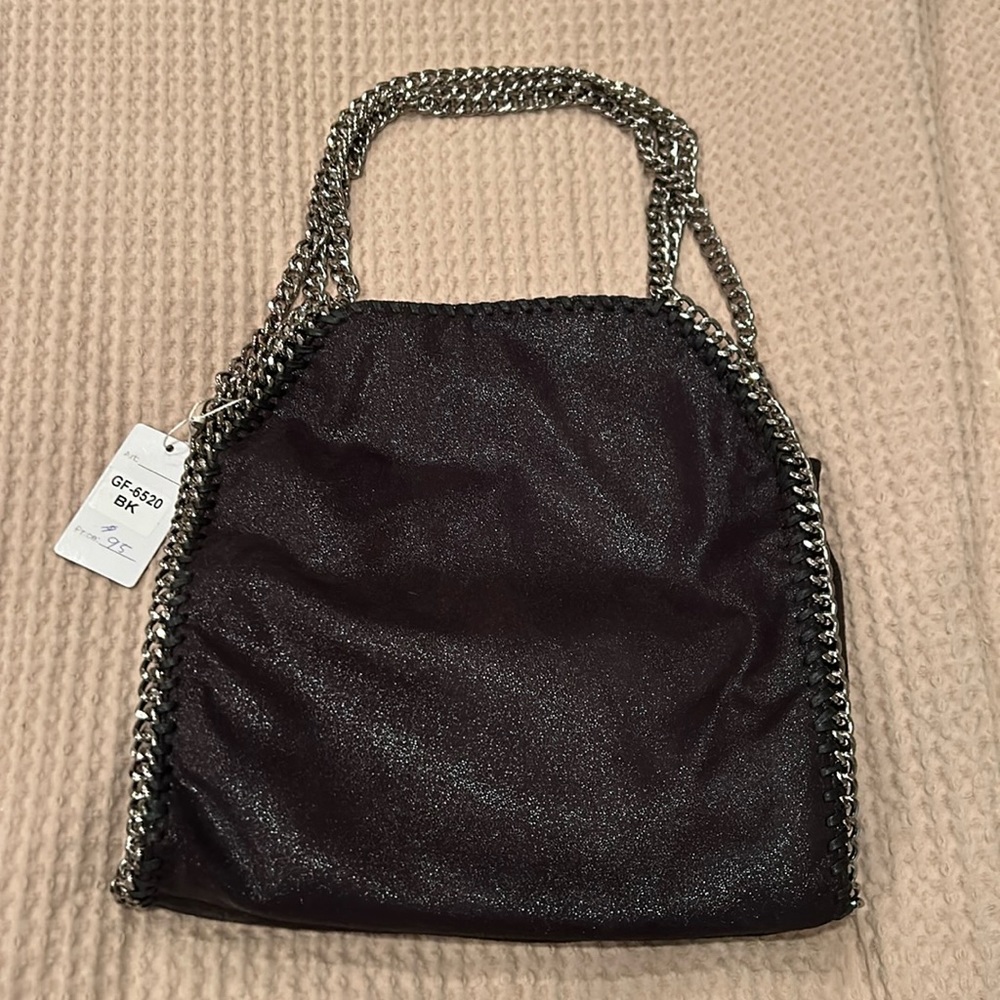 Black pocketbook with three silver chains. Black has a sparkly sheen to it.